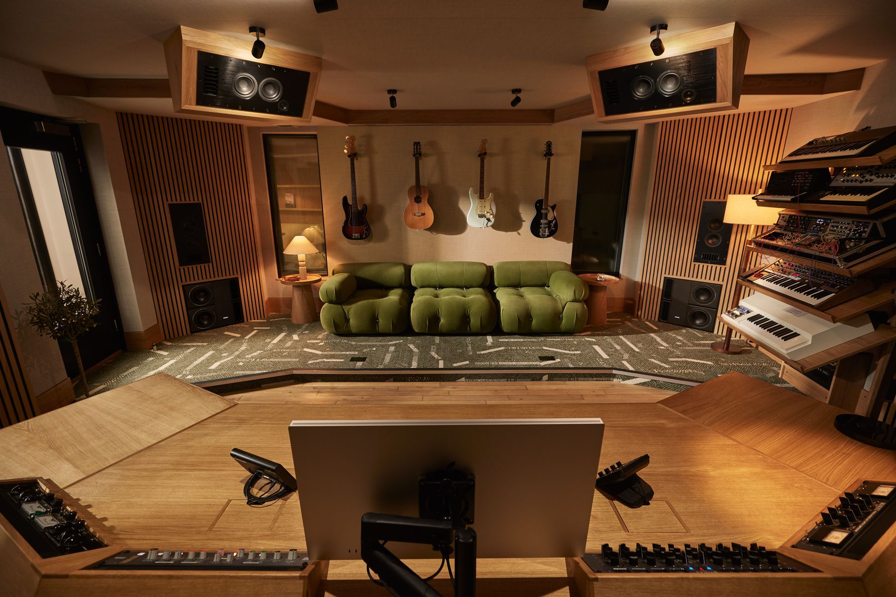 The control room seen from behind the mixing desk, looking across to the lounge, guitars and synth wall