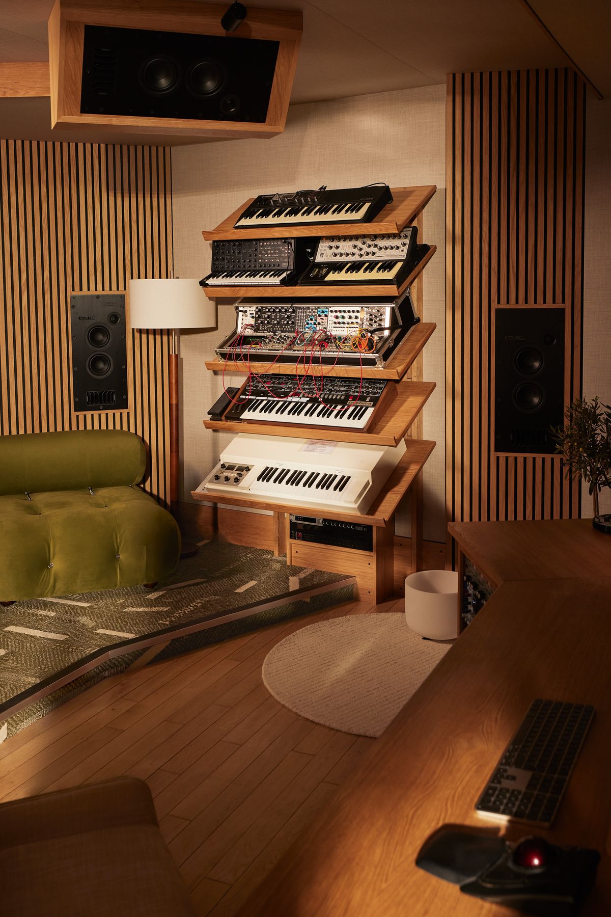 Tiered oak stand holding synthesizers beside the lounge